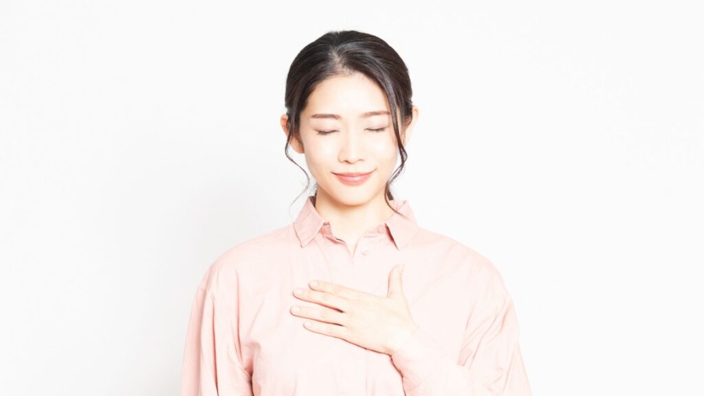 胸に手を当てる_女性