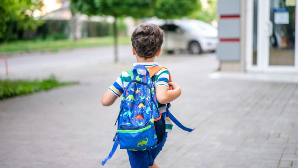 青い恐竜のリュック 男の子の後ろ姿