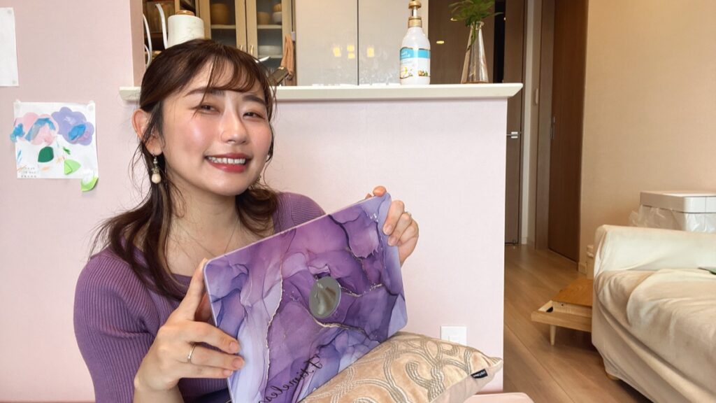 なかのかほ　紫のニットでパソコンのふたを見せて笑顔